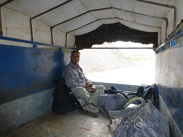On a sack of potatoes in the back of a truck