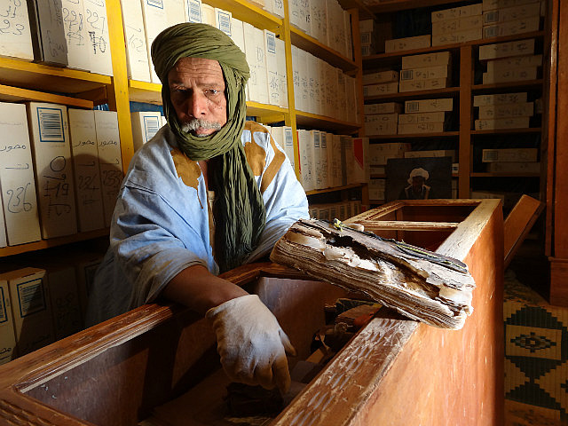 Saif showing one of the ancient manuscripts 