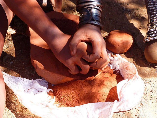 Pounding ochre stone to powder