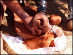 Pounding ochre stone to powder