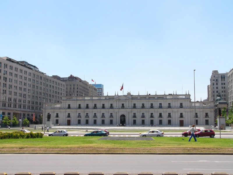 P1080107.JPG - The impressive Palacio de la Moneda from the Plaza de la Constitucion. Originally the colonial mint and formerly the presidential residence, this edifice occupies an entire block. It was damaged by the airforce during the 1973 military coup and was restored before the return to democracy. It now houses the presidential offices though the president does not reside here.
