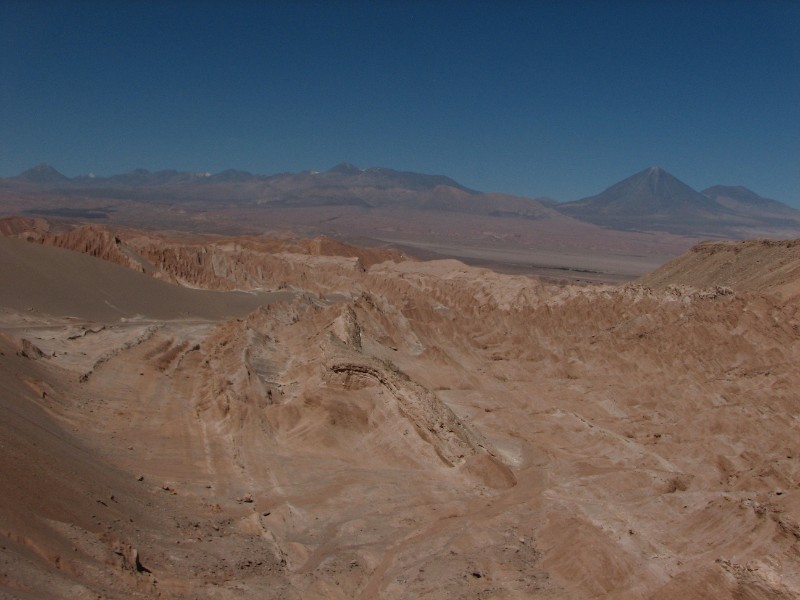 IMG_5349.jpg - The earth is creased all around, like a crushed paper tissue. Volcan Licancabur at 5,920 metres (19,423 ft) is seen in the background. Its peak is on the border between Chile and Bolivia.