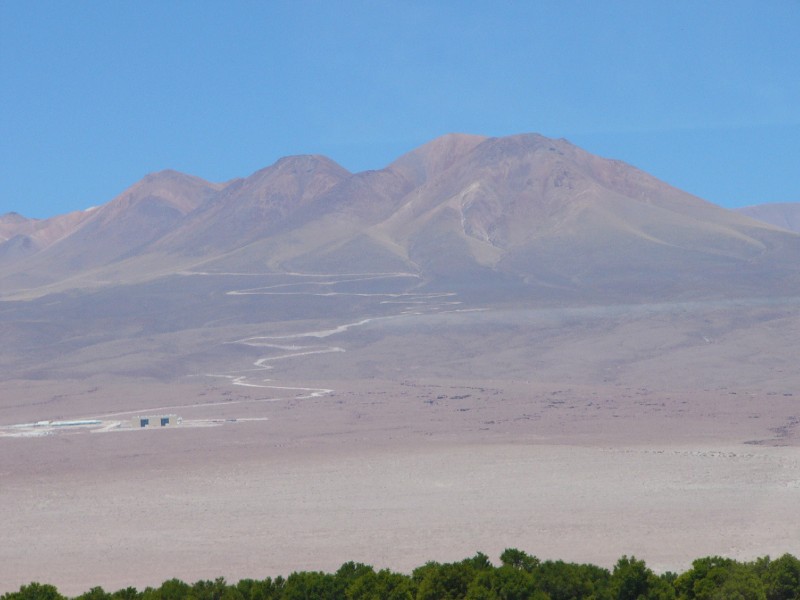 P1080346.JPG - The road leading upto the ALMA (Atacama Large Milllimeter Array) project site. A joint project involving USA, Canada, Europe and Chile. More info at http://www.alma.cl/  This array of 64 telescopes is located in the Atacama Desert of Chile because the sky above has the unsurpassed clarity and stability essential for millimeter wave astronomy. The millimeter and sub-millimeter radiation that ALMA will study is able to penetrate the vast clouds of dust and gas that populate interstellar and intergalactic space, revealing previously hidden details about astronomical objects. This energy, however, is blocked by atmospheric moisture here on Earth. To conduct research in this critical portion of the spectrum, astronomers need a site that is very dry, and preferably at a very high altitude where the atmosphere is thinner. Extensive tests showed that the sky above the high-altitude Chajnantor plain in the Atacama Desert has the unsurpassed clarity and stability needed to perform efficient observations with ALMA.  