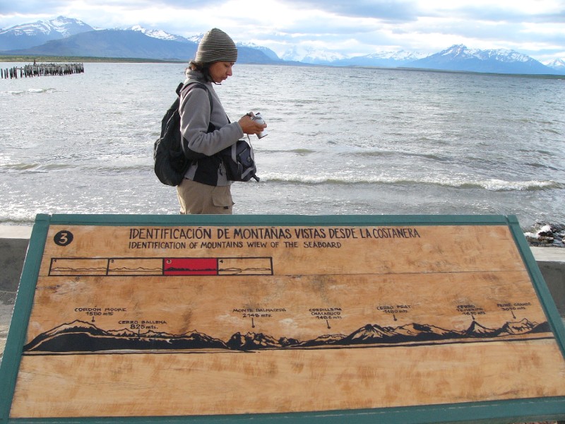 P1090261.JPG - Puerto Natales waterfront (Seno de Ultima Esperanza or Last Hope Inlet) with the view of mountains nearby. They are identified in the display. There are 4 such displays, this is the third as indicated by the red background in the contextual diagram above. l-to-r: Cordon Moore (1580m), Monte Balmaceda (2148m) - obscured by clouds, Cerro Prat  (1180m) the prominent dark mountain on the right and Co. Tenerife (1560m) on the right edge.