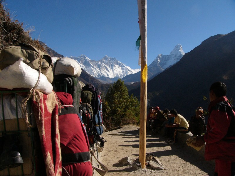 P1100498.JPG - Porters taking a break on the trail with Everest, Lhotse and Ama Dablam offering them no help.