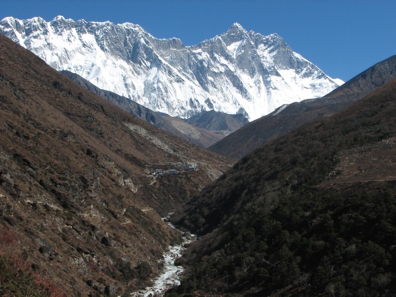 IMG_8188.JPG - The presence of Everest and Lhotse was almost constant on Day 5. However, Everest was slowly disappearing behind the obscuring wall and eventually disappeared from view. The Imja Khola river accompanies the trail. We are approaching a village.