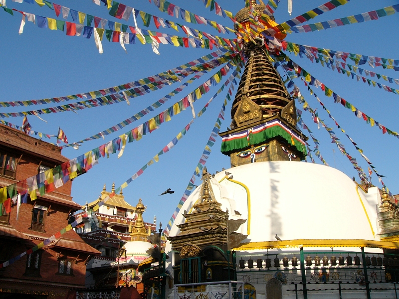 P1100394.JPG - Kathesimbhu Stupa - Kathesimbhu means "Kathmandu Swayambhu". Not only is the stupa easily recognized as a smaller version of the one at Swayambhu, it also claims to have been built from stones and earth left over from the latter. Thus a walk around the Kathesimbhu stupa promises the old and lame the same blessings as a pilgrimage to Swayambhunath's hill.Although the present stupa dates only from the 17th c., the many chaityas with votive stupas and sculptures of gods from the Mahayana pantheon show the site itself to be considerably older.