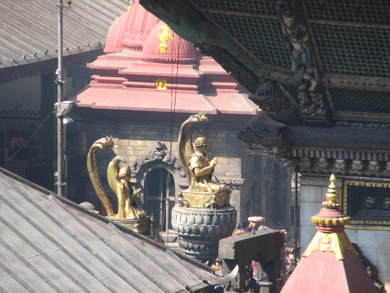 IMG_8446.JPG - On the left side, atop stone pillars, are golden figures of past kings kneeling in prayer under a protective hood of a snake.